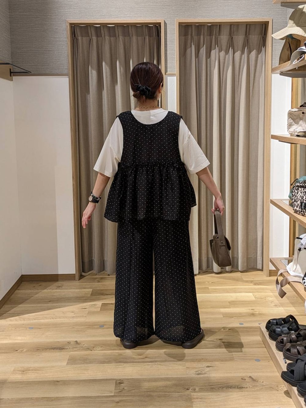 ブラウン系のサンダル、ブラック系のその他パンツ、ブラック系のベストを着用したレディースの夏コーディネートの2枚目の写真