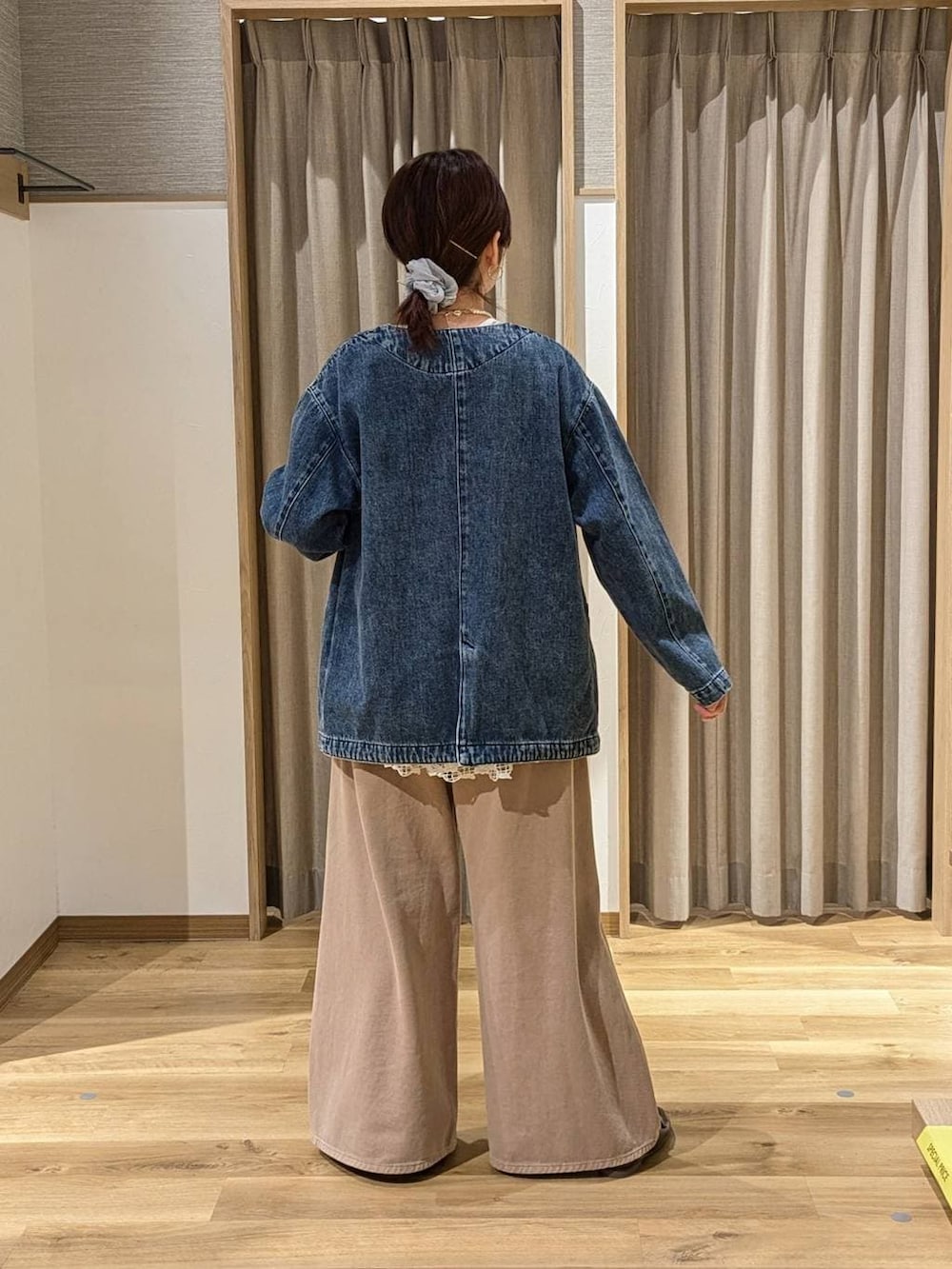 ベージュ系のデニムパンツ、ブルー系のノーカラージャケット、ブラウン系のトートバッグを着用したレディースの春コーディネートの2枚目の写真