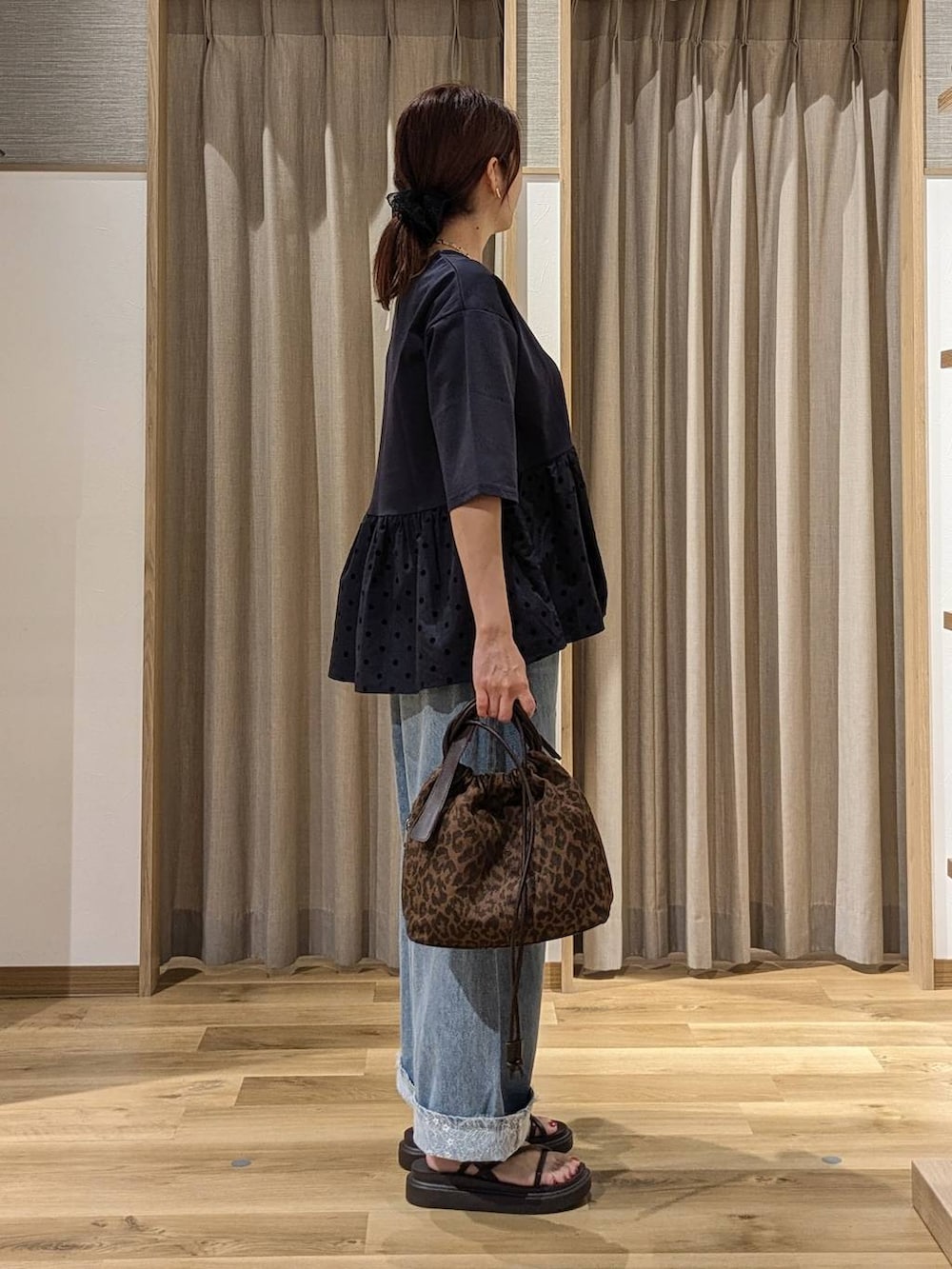 ブルー系のデニムパンツ、ブルー系のTシャツ/カットソー、ブラウン系のショルダーバッグを着用したレディースの夏コーディネートの2枚目の写真