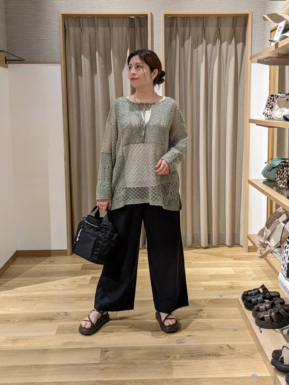 ブラウン系のサンダル、ブラック系のその他パンツ、グリーン系のTシャツ/カットソーを着用したレディースの夏コーディネートの3枚目の写真