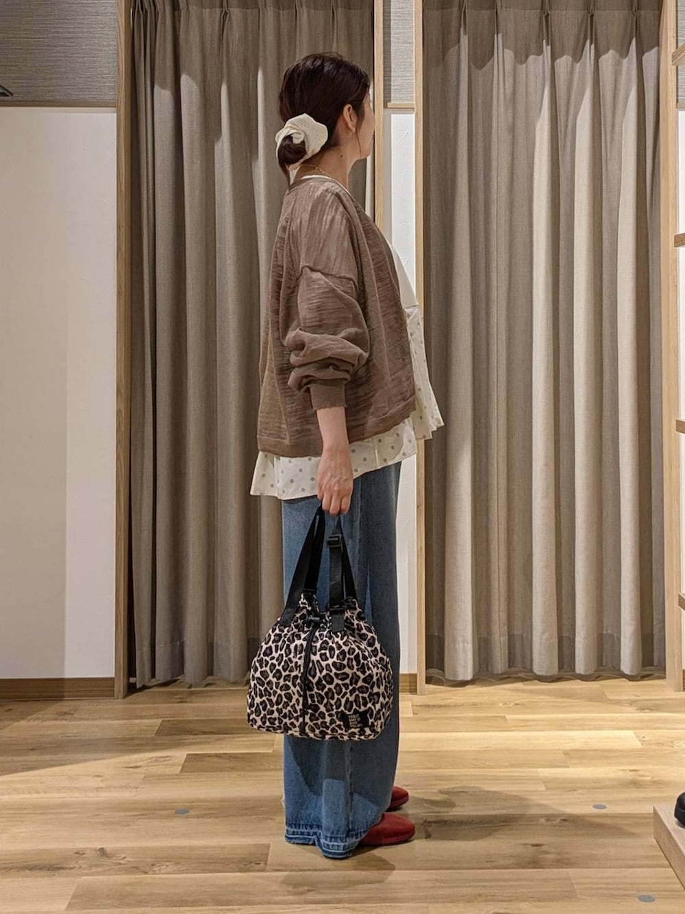 レッド系のその他シューズ、ベージュ系のTシャツ/カットソー、ブルー系のデニムパンツを着用したレディースの秋コーディネートの2枚目の写真