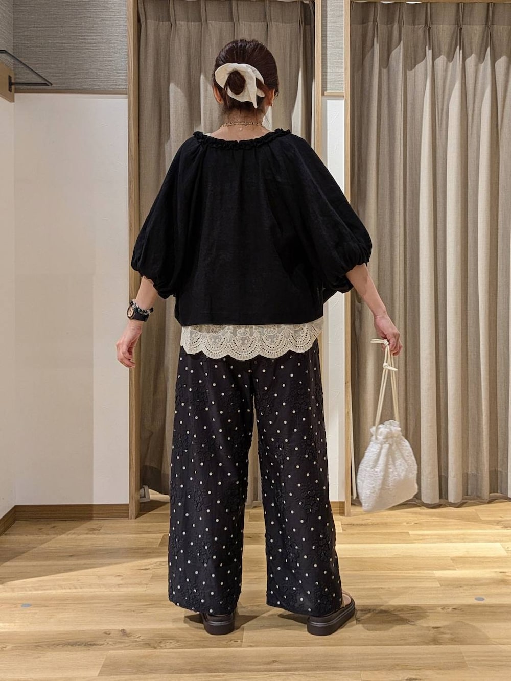 ブラック系のその他パンツ、ベージュ系のベスト、ベージュ系のサンダルを着用したレディースの夏コーディネートの3枚目の写真