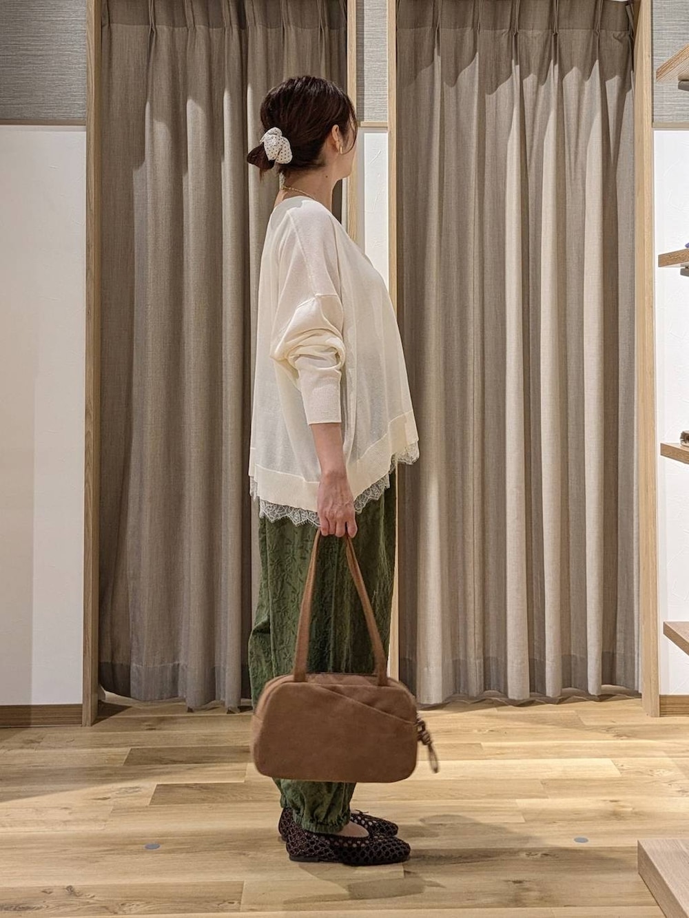 ブラウン系のショルダーバッグ、グリーン系のその他パンツ、ホワイト系のカーディガン/ボレロを着用したレディースの秋コーディネートの2枚目の写真