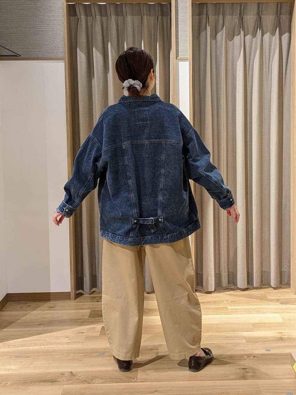 ブルー系のデニムジャケット、ブラウン系のローファー、ブルー系のニット/セーターを着用したレディースの春コーディネートの2枚目の写真