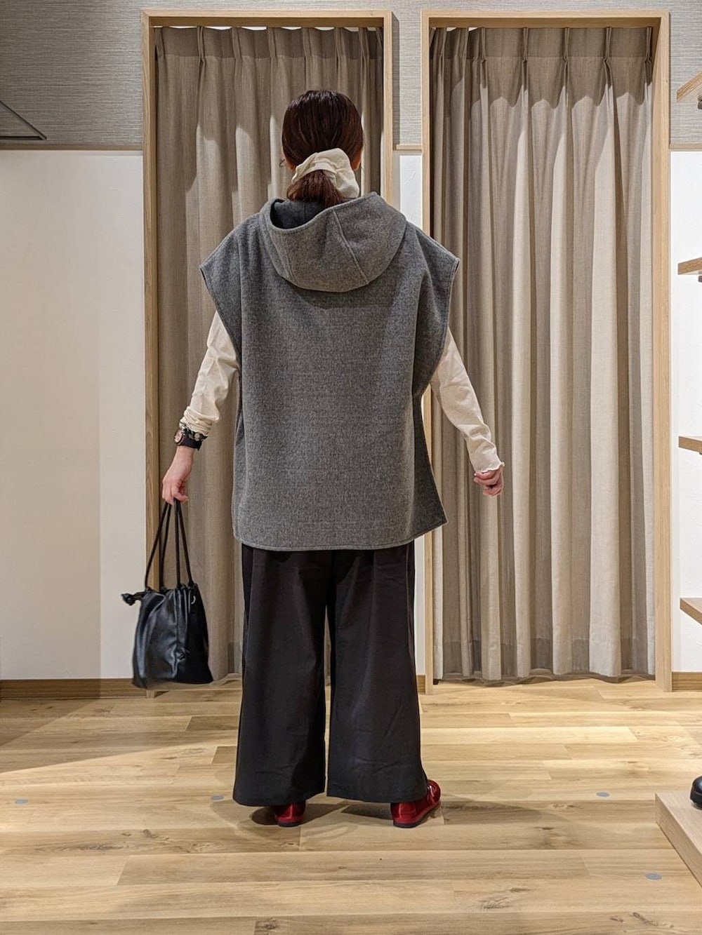 レッド系のその他シューズ、グレー系のその他アウター、ブラック系のショルダーバッグを着用したレディースの秋コーディネートの3枚目の写真