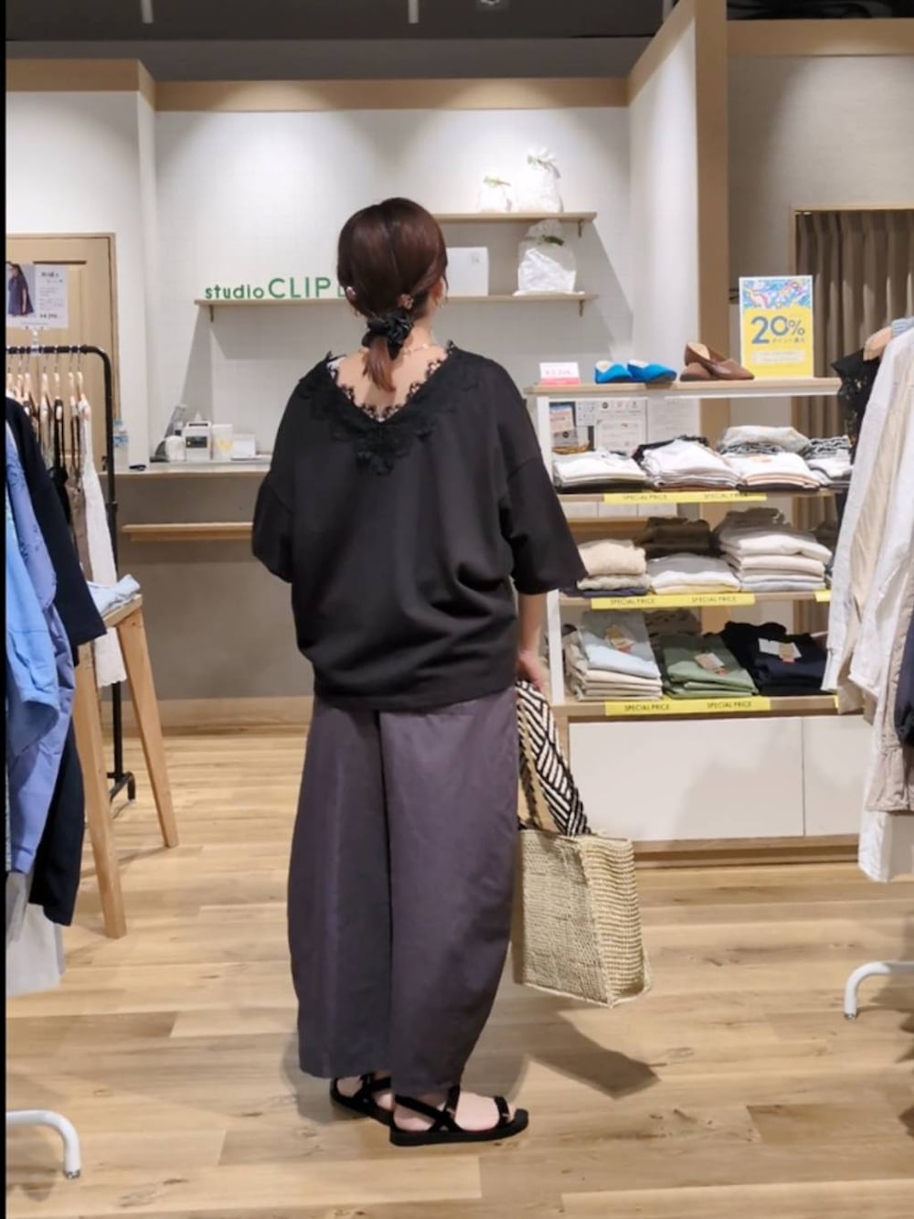 ベージュ系のトートバッグ、ブラック系のサンダル、ホワイト系のタンクトップを着用したレディースの春コーディネートの2枚目の写真