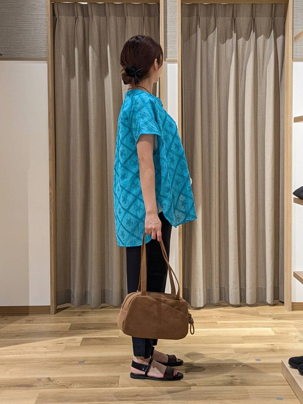 ブラウン系のショルダーバッグ、ブルー系のその他パンツ、ブラウン系のサンダルを着用したレディースの夏コーディネートの2枚目の写真