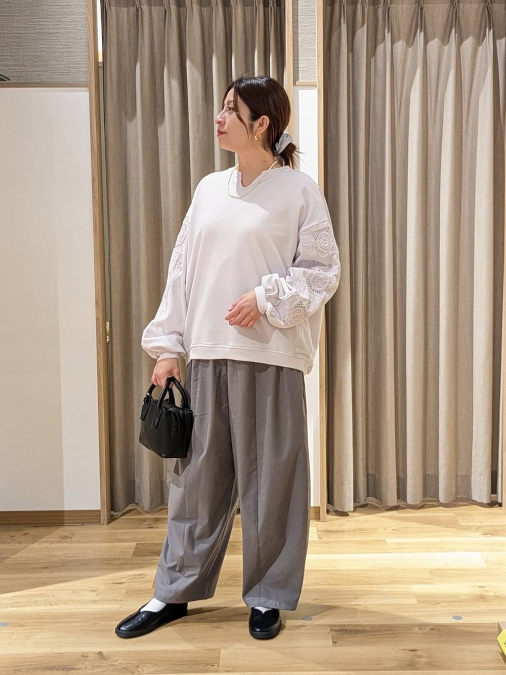 ブラック系のスニーカー、グレー系のその他パンツ、ブラック系のトートバッグを着用したレディースの冬コーディネートの2枚目の写真