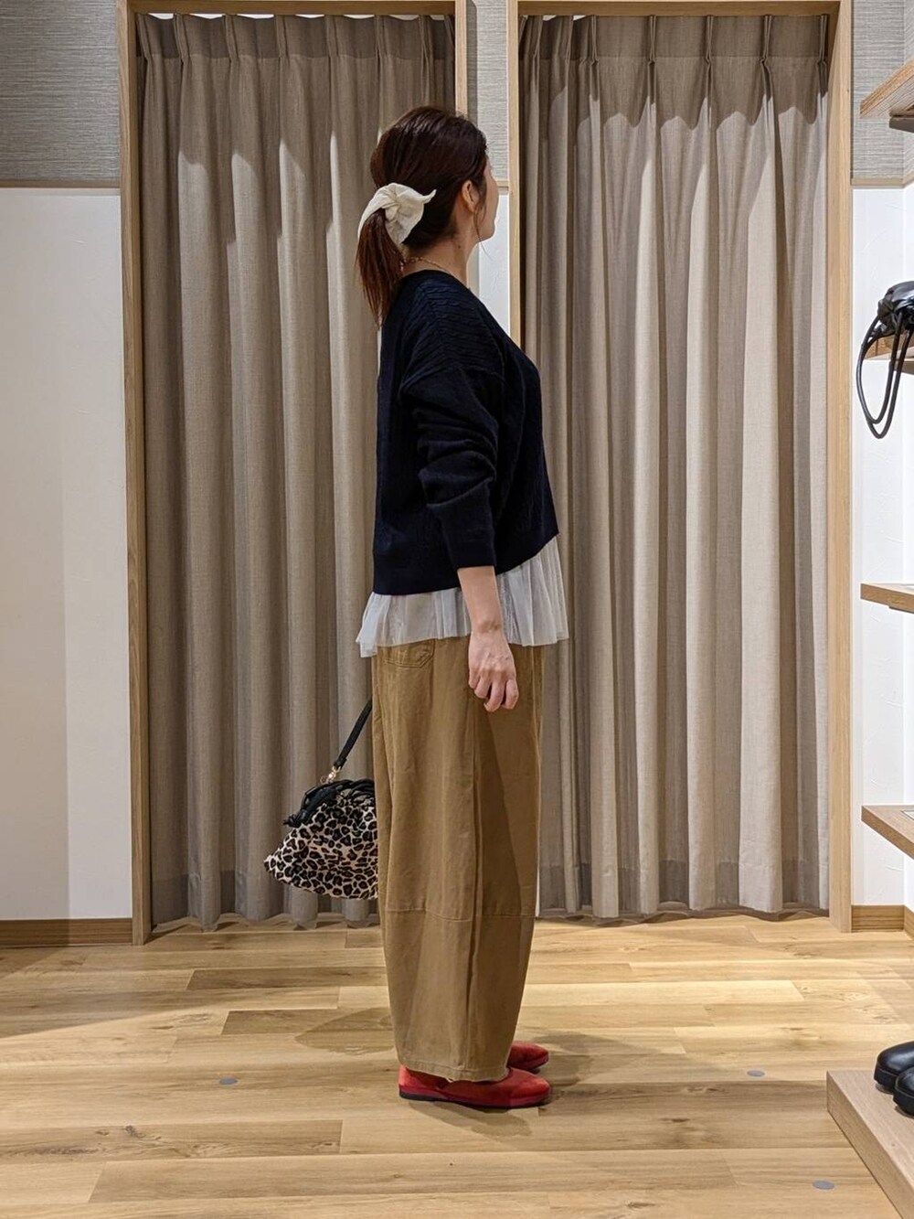 レッド系のその他シューズ、その他のTシャツ/カットソー、ブラウン系のショルダーバッグを着用したレディースの秋コーディネートの2枚目の写真