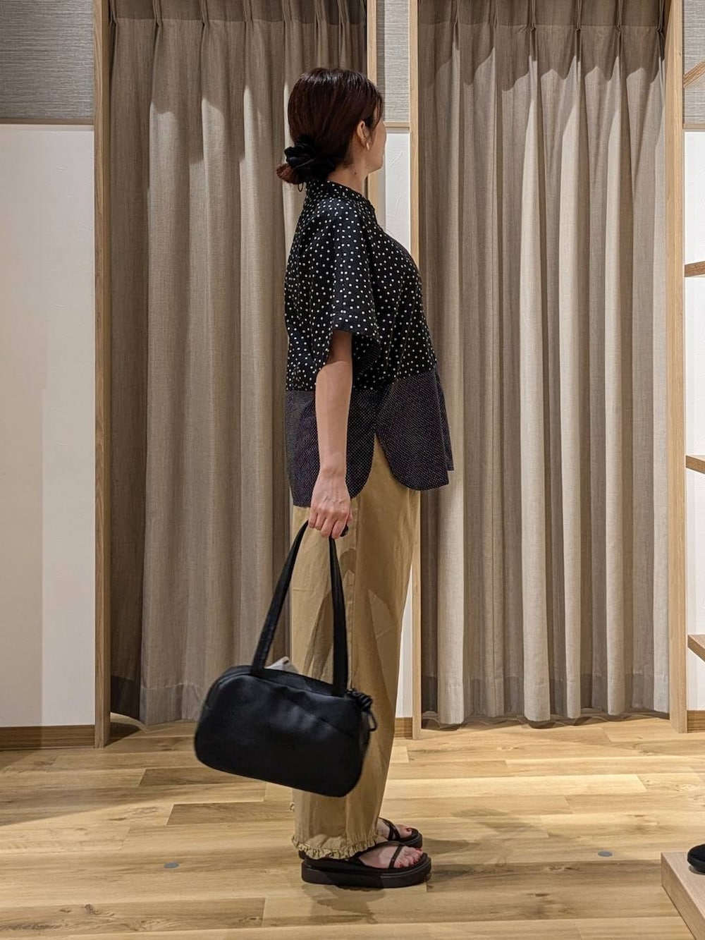 ブラック系のショルダーバッグ、ベージュ系のその他パンツ、ブラック系のシャツ/ブラウスを着用したレディースの夏コーディネートの2枚目の写真