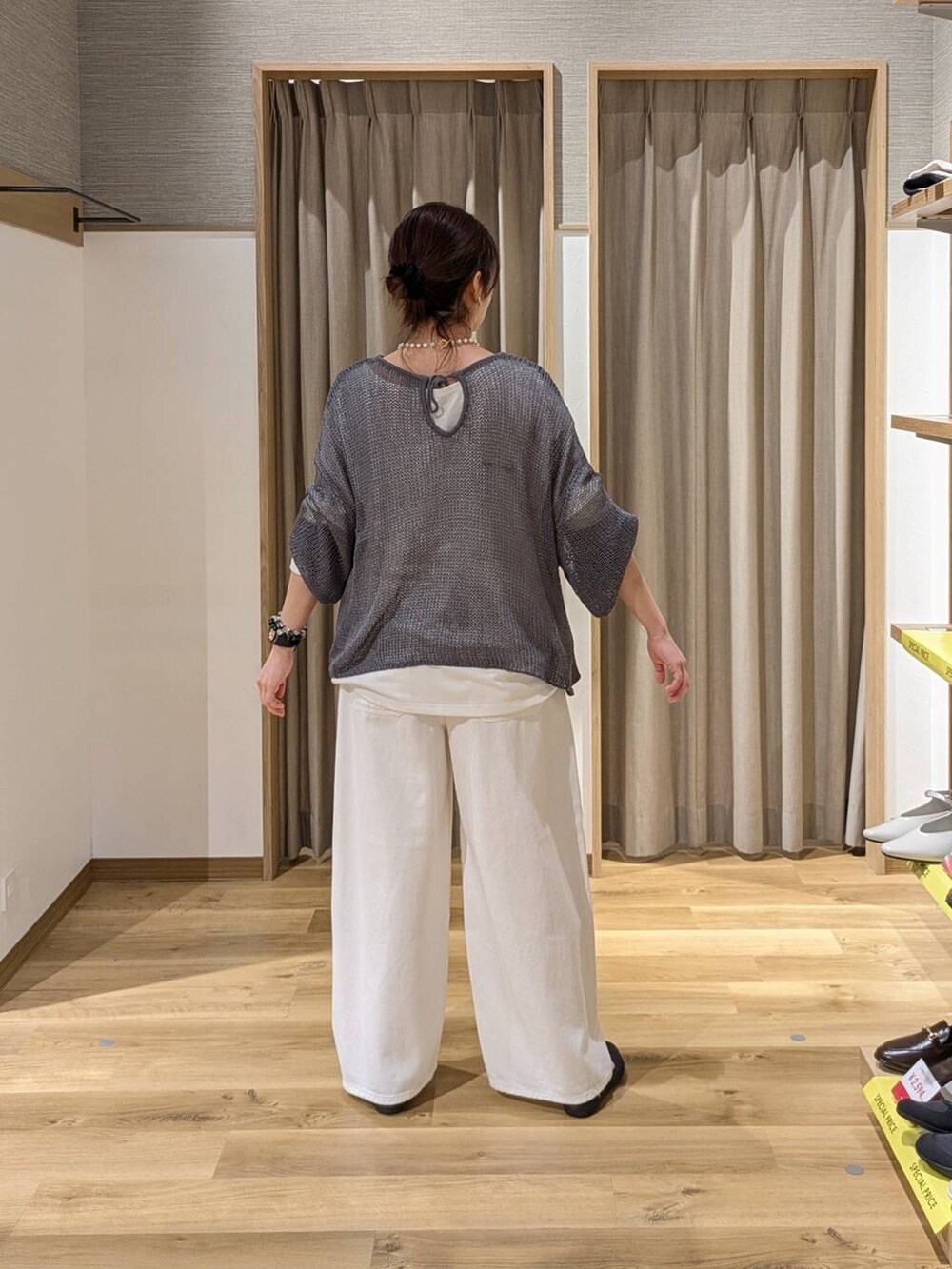 ブルー系のデニムパンツ、グレー系のニット/セーター、グレー系のパンプスを着用したレディースの春コーディネートの2枚目の写真