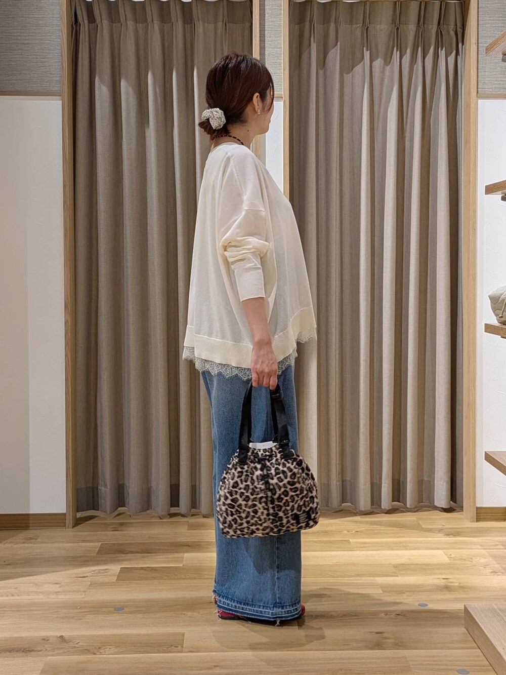 レッド系のその他シューズ、ホワイト系のカーディガン/ボレロ、ブルー系のデニムパンツを着用したレディースの秋コーディネートの2枚目の写真
