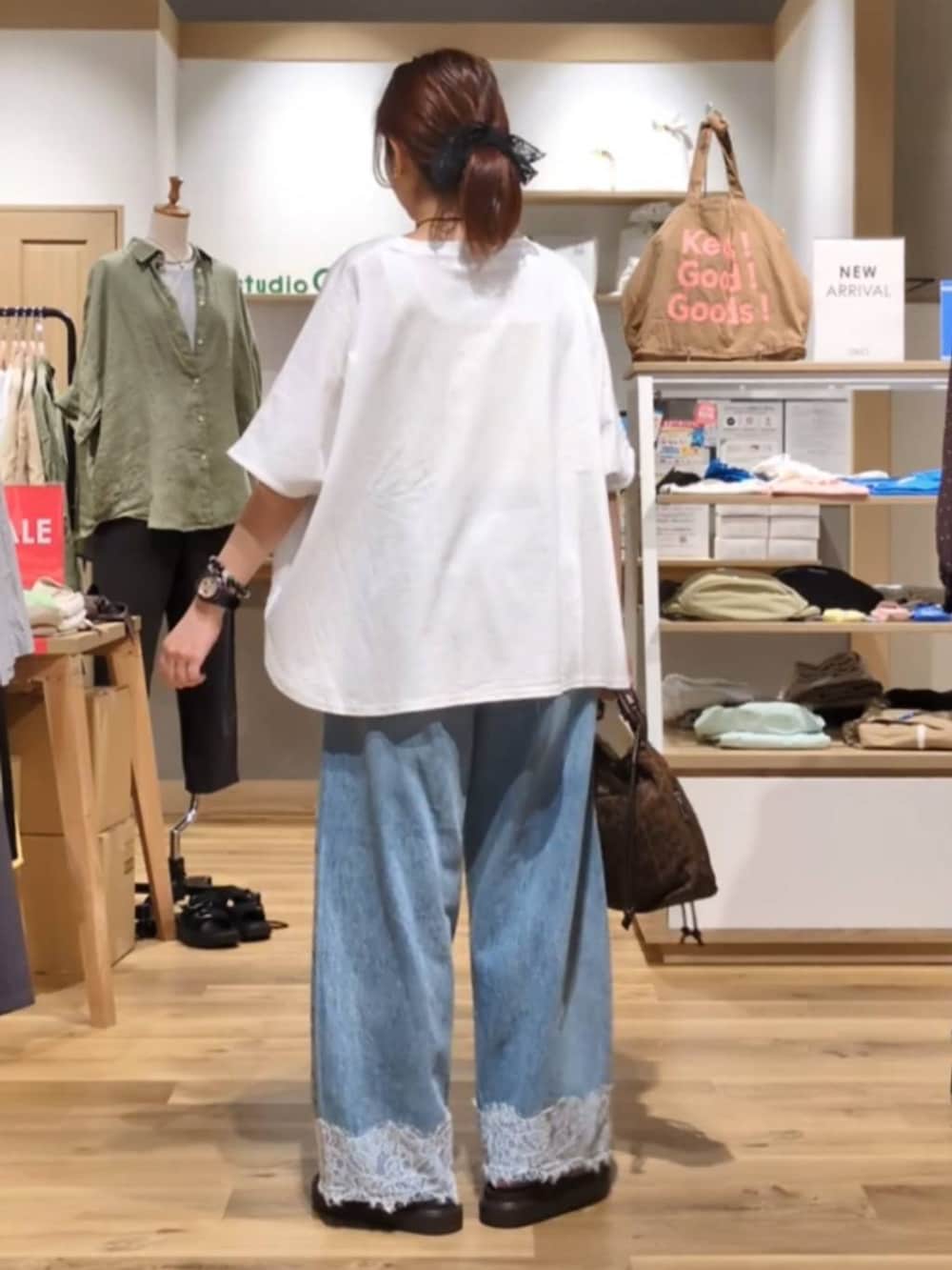 ブルー系のデニムパンツ、ブラウン系のサンダル、その他のTシャツ/カットソーを着用したレディースの夏コーディネートの3枚目の写真