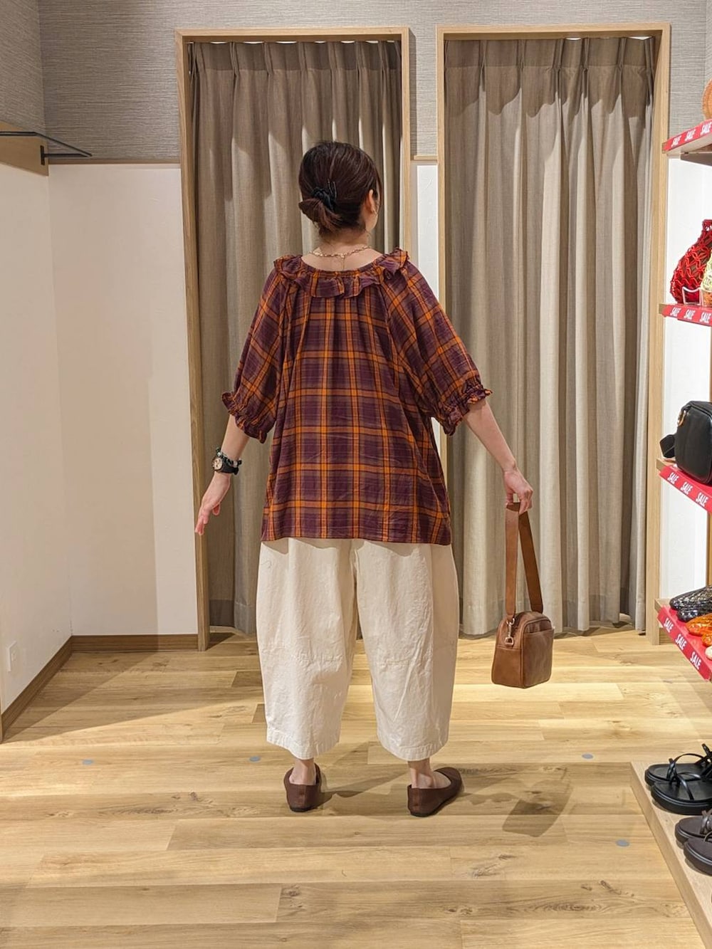 ブラウン系のショルダーバッグ、ホワイト系のタンクトップ、レッド系のシャツ/ブラウスを着用したレディースの夏コーディネートの2枚目の写真