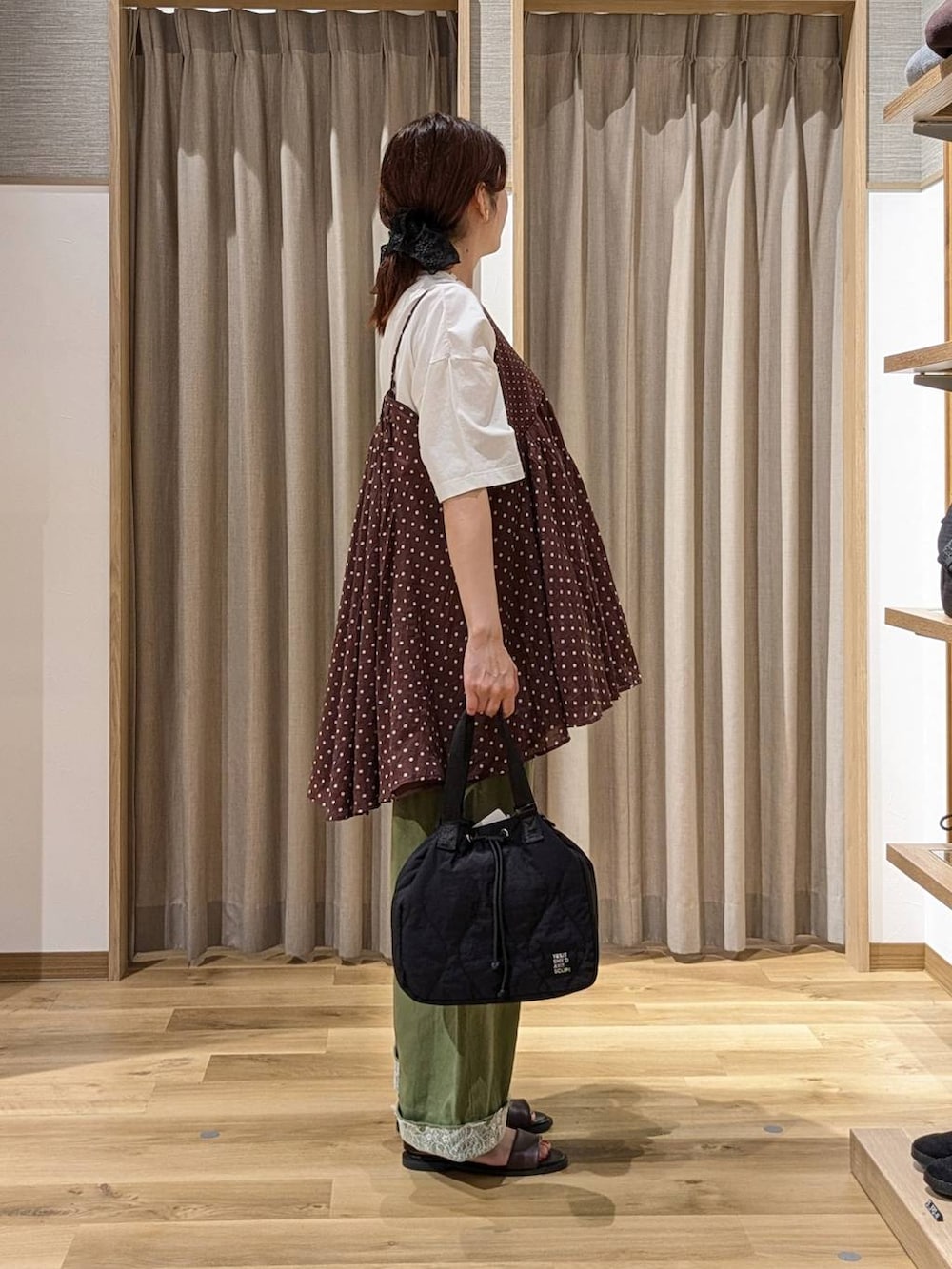 グリーン系のデニムパンツ、ブラウン系のサンダル、ホワイト系のTシャツ/カットソーを着用したレディースの夏コーディネートの2枚目の写真