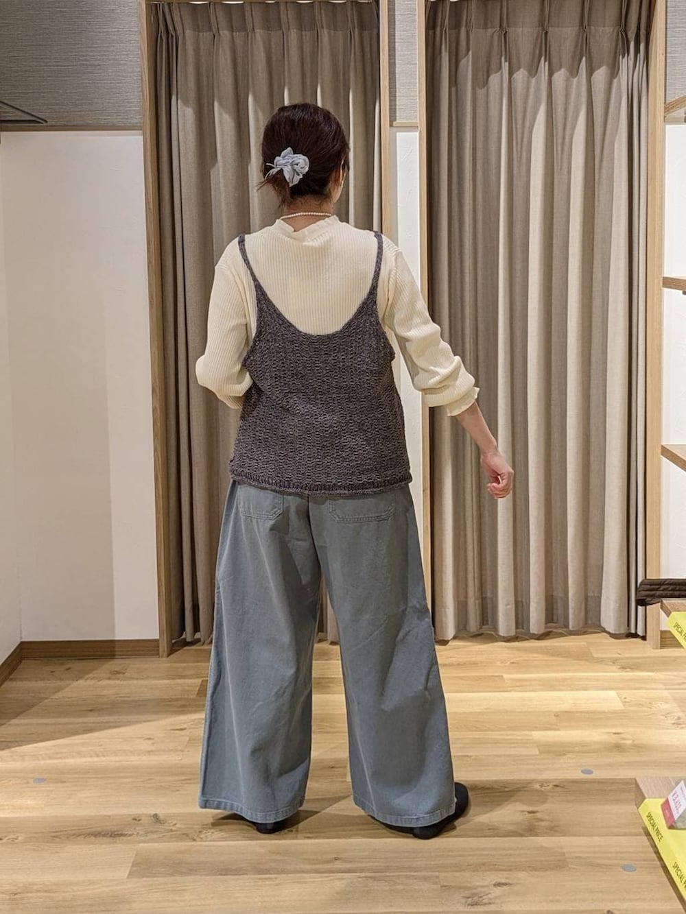 ブルー系のチノパンツ、グレー系のパンプス、ホワイト系のニット/セーターを着用したレディースの春コーディネートの2枚目の写真