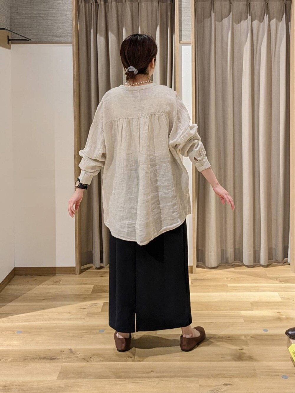 ベージュ系のシャツ/ブラウス、ブラック系のトートバッグ、ブラウン系のパンプスを着用したレディースの春コーディネートの2枚目の写真