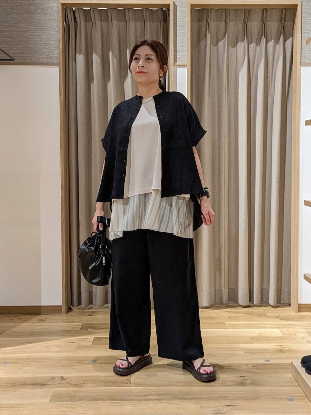 ブラック系のシャツ/ブラウス、グレー系のTシャツ/カットソー、ブラウン系のサンダルを着用したレディースの夏コーディネートの2枚目の写真