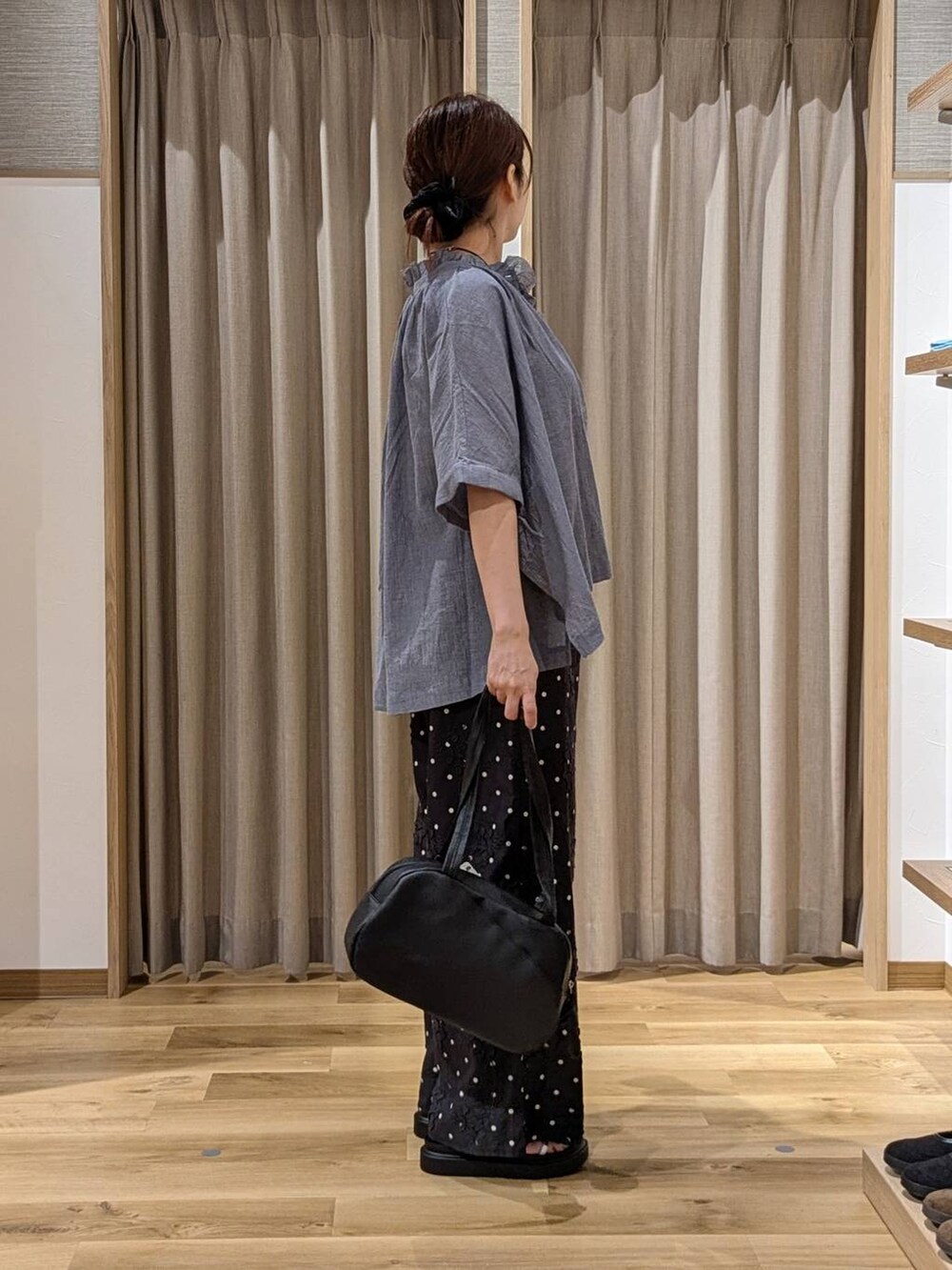 ブラック系のショルダーバッグ、ブラック系のその他パンツ、ブルー系のシャツ/ブラウスを着用したレディースの夏コーディネートの2枚目の写真
