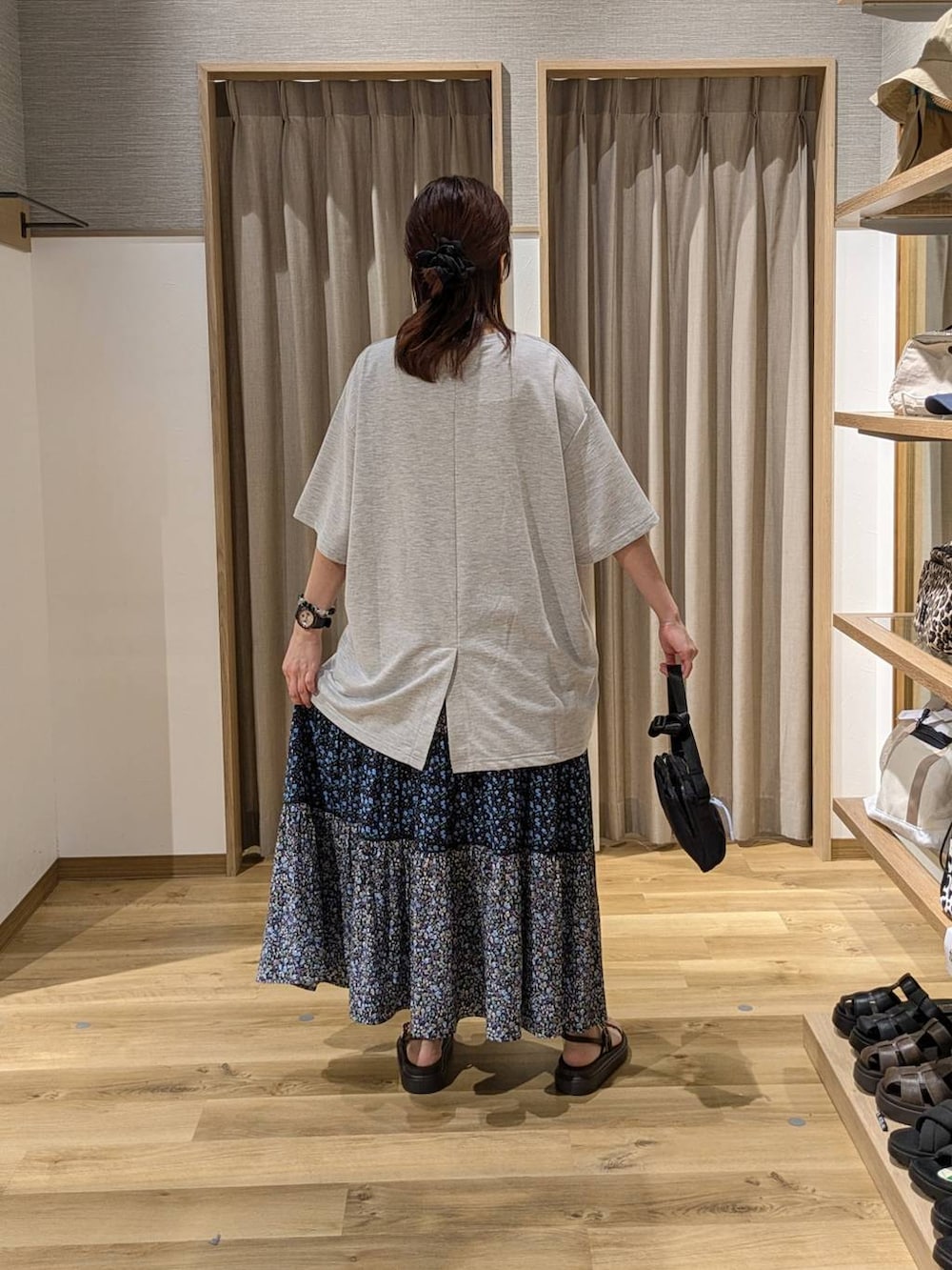 ブラウン系のサンダル、ブルー系のスカート、ブラック系のショルダーバッグを着用したレディースの夏コーディネートの2枚目の写真