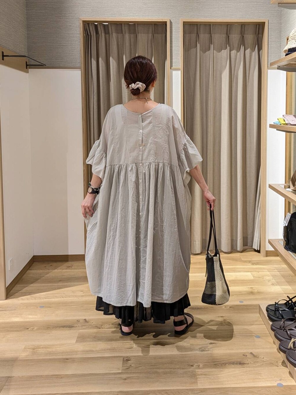 ブラック系のトートバッグ、ブラウン系のサンダル、ブラック系のスカートを着用したレディースの夏コーディネートの2枚目の写真