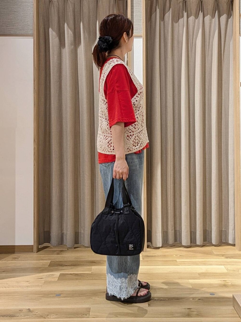 ブルー系のデニムパンツ、レッド系のTシャツ/カットソー、ベージュ系のベストを着用したレディースの夏コーディネートの2枚目の写真