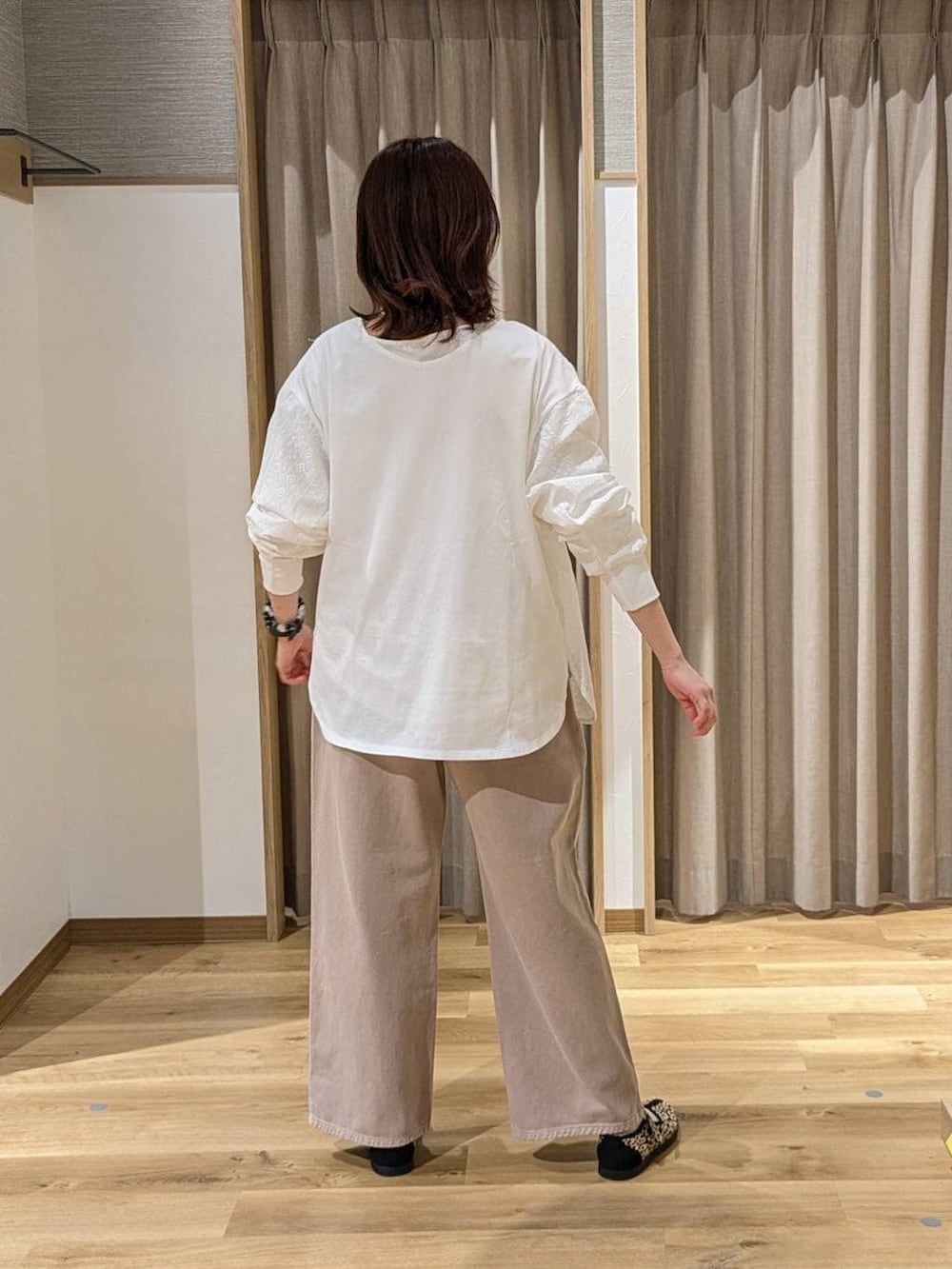 ベージュ系のデニムパンツ、その他のスニーカー、ブラウン系のトートバッグを着用したレディースの春コーディネートの2枚目の写真