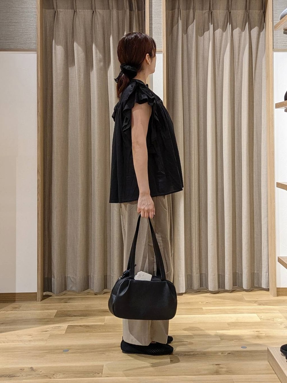 ブラック系のシャツ/ブラウス、ブラック系のショルダーバッグ、ブラック系のパンプスを着用したレディースの夏コーディネートの2枚目の写真