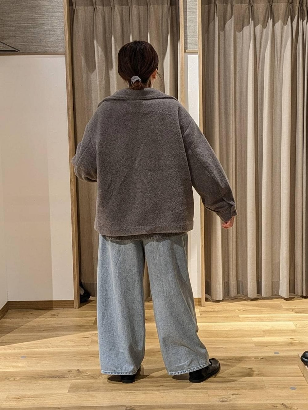 グレー系のブルゾン、グレー系のカーディガン/ボレロ、ホワイト系のTシャツ/カットソーを着用したレディースの冬コーディネートの2枚目の写真