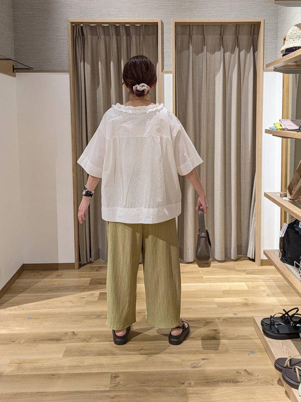 イエロー系のその他パンツ、ブラウン系のサンダル、ブラウン系のショルダーバッグを着用したレディースの夏コーディネートの2枚目の写真