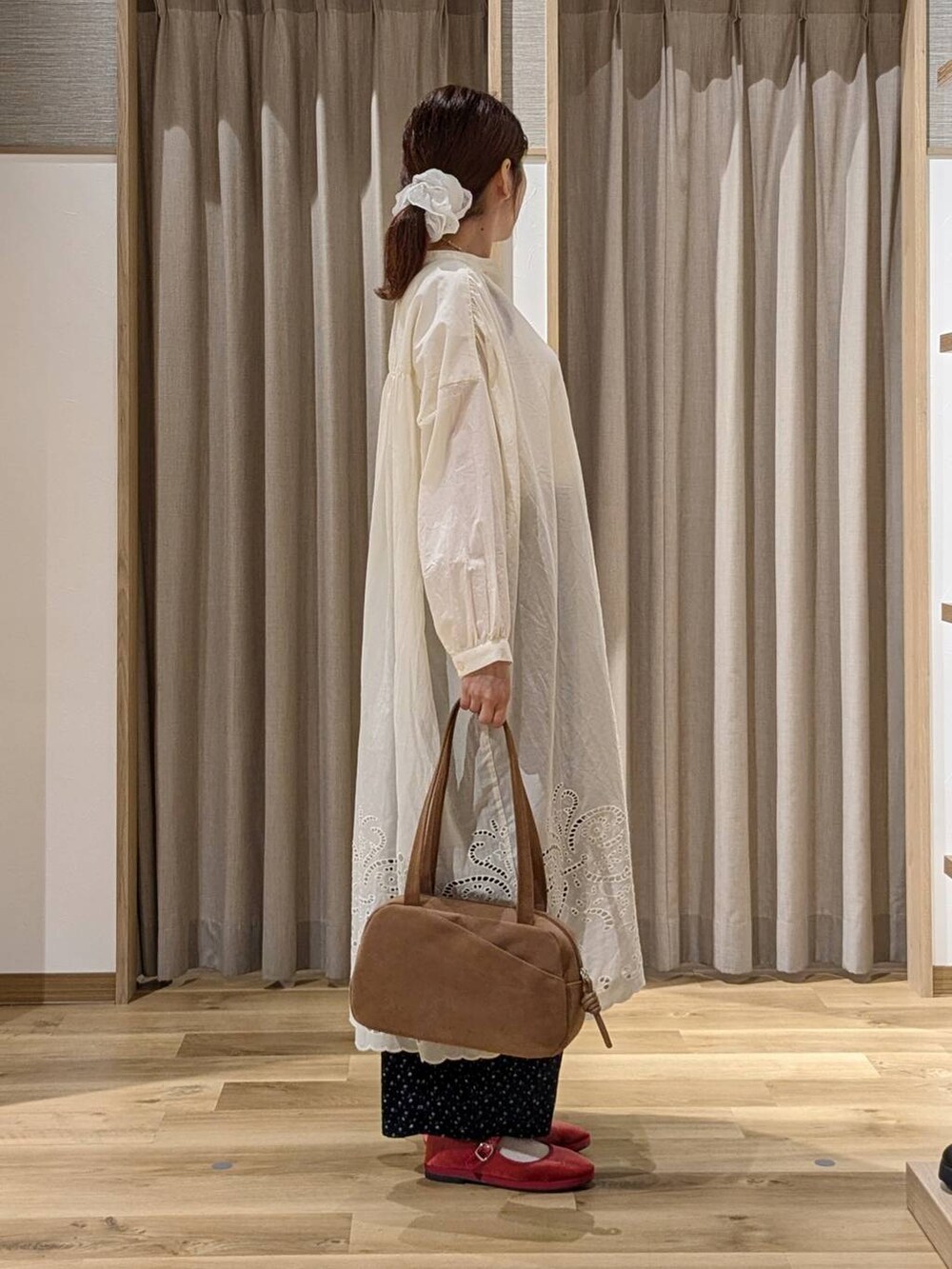 ブラウン系のショルダーバッグ、ブルー系のその他パンツ、レッド系のその他シューズを着用したレディースの秋コーディネートの2枚目の写真