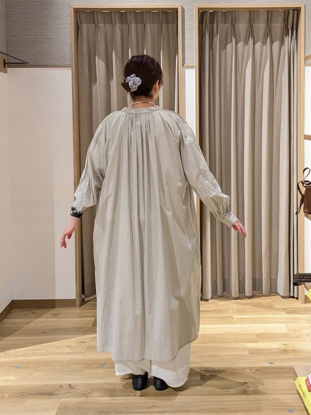 ホワイト系のデニムパンツ、グレー系のワンピース、ブラック系のトートバッグを着用したレディースの春コーディネートの2枚目の写真