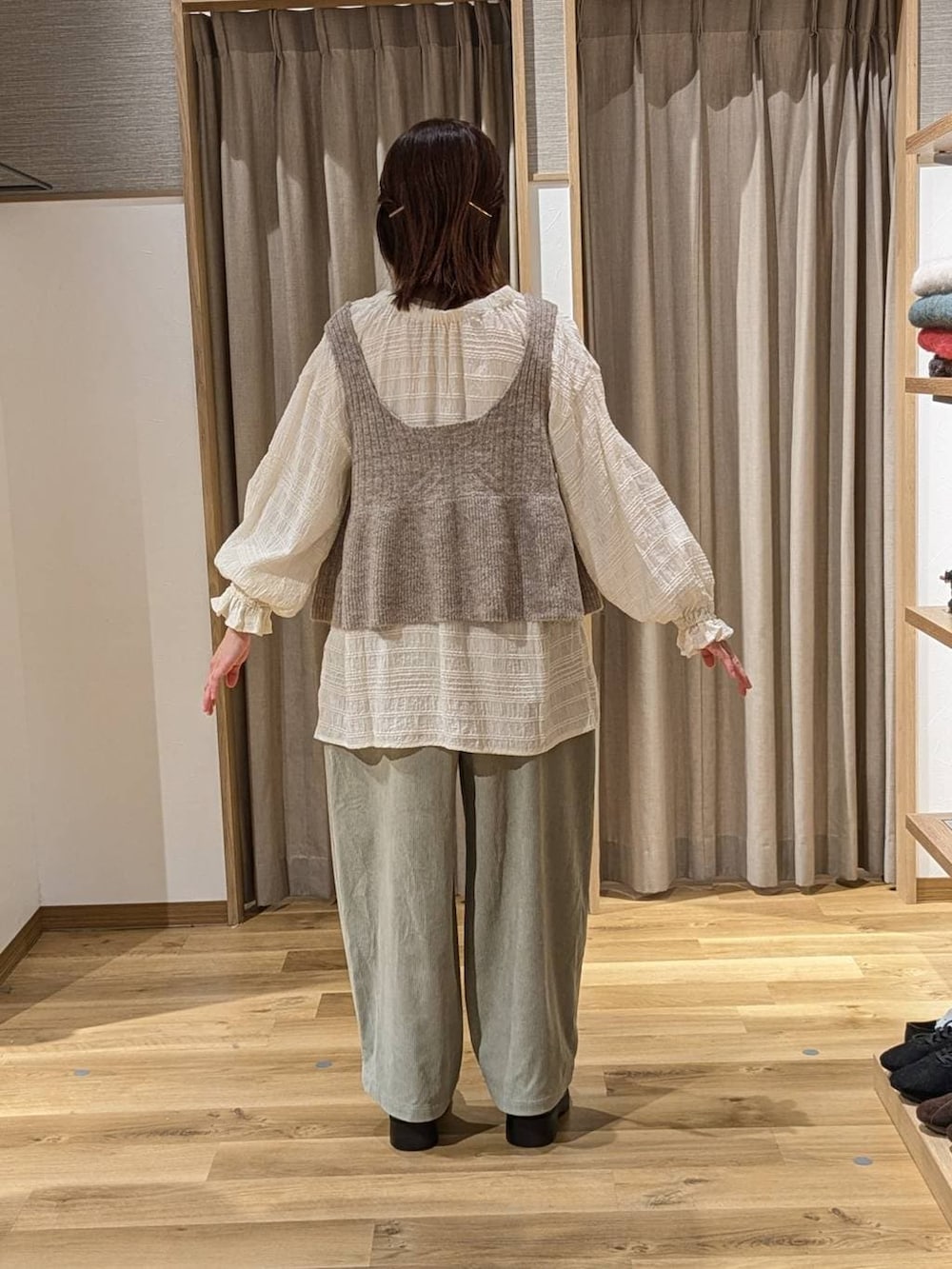 ブラック系のブーツ、ベージュ系のベスト、ホワイト系のシャツ/ブラウスを着用したレディースの冬コーディネートの3枚目の写真