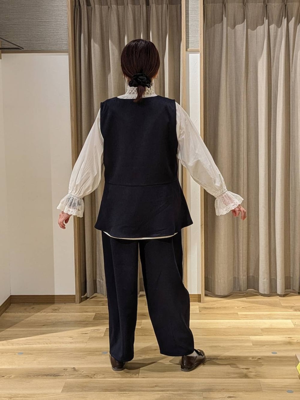 ブルー系のスーツセット、ブラウン系のトートバッグ、ホワイト系のシャツ/ブラウスを着用したレディースの冬コーディネートの2枚目の写真