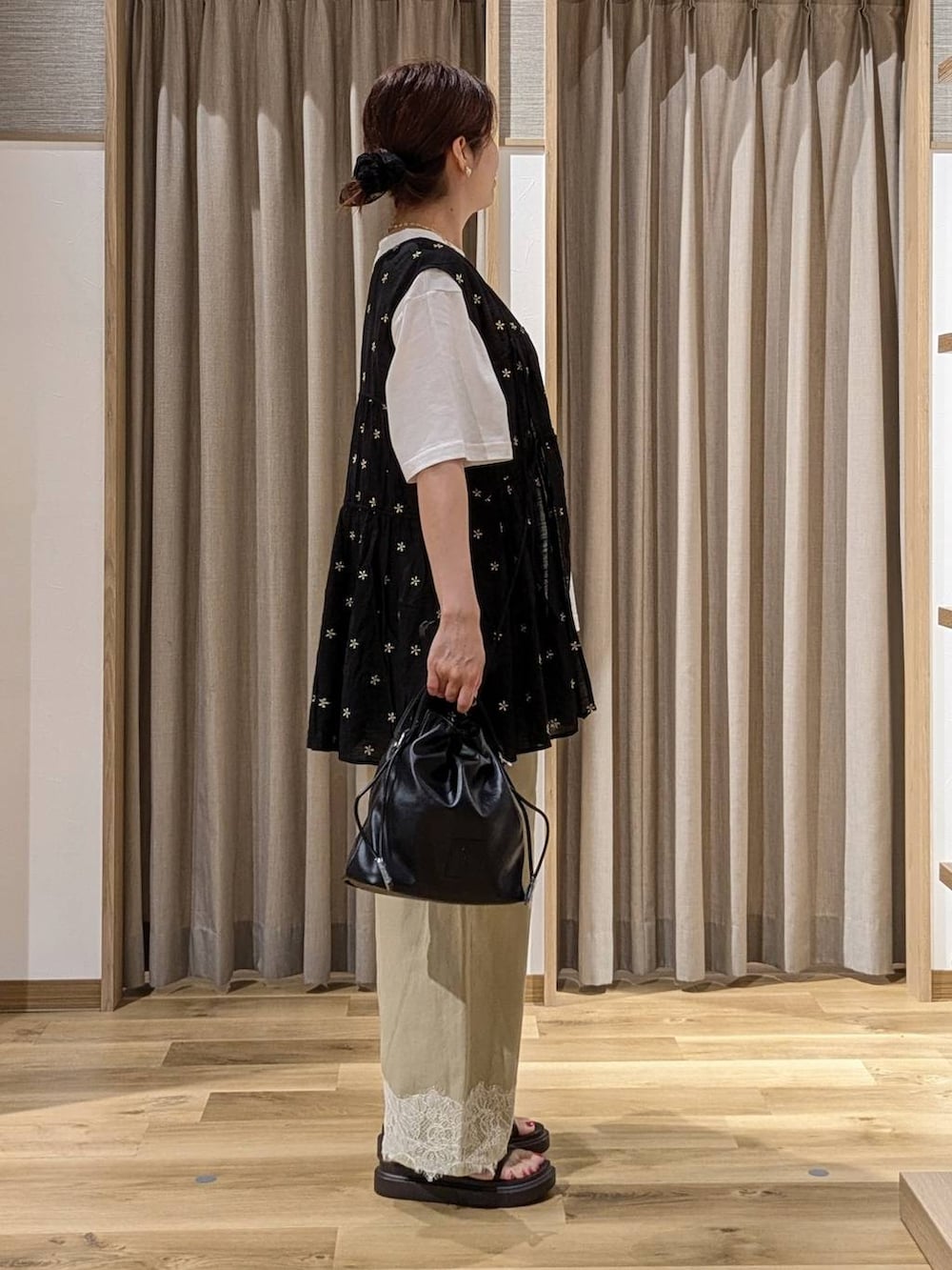 ベージュ系のデニムパンツ、ホワイト系のTシャツ/カットソー、ブラック系のチュニックを着用したレディースの夏コーディネートの2枚目の写真