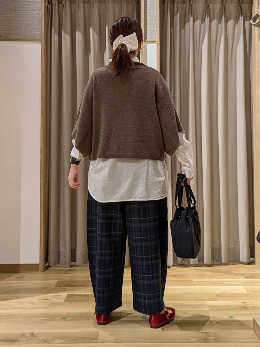 レッド系のその他シューズ、ブラウン系のベスト、ブラック系のその他パンツを着用したレディースの秋コーディネートの3枚目の写真