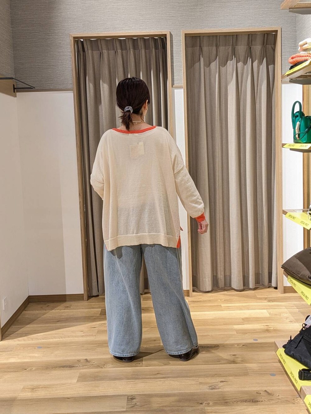 ブルー系のデニムパンツ、ベージュ系のトートバッグ、ブラウン系のローファーを着用したレディースの春コーディネートの2枚目の写真