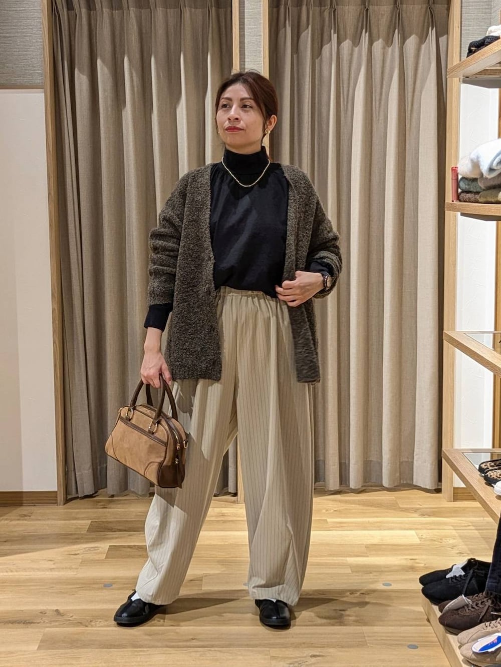 ブラック系のシャツ/ブラウス、ブラウン系のカーディガン/ボレロ、ブラウン系のショルダーバッグを着用したレディースの冬コーディネートの2枚目の写真