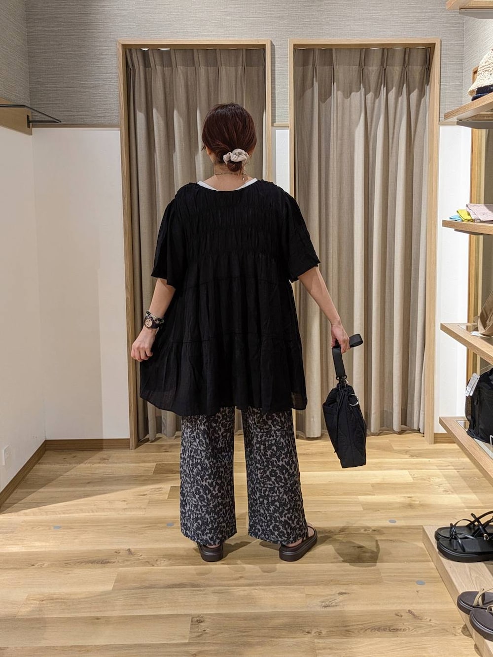 ブラック系のショルダーバッグ、ブラウン系のサンダル、その他のその他パンツを着用したレディースの夏コーディネートの2枚目の写真