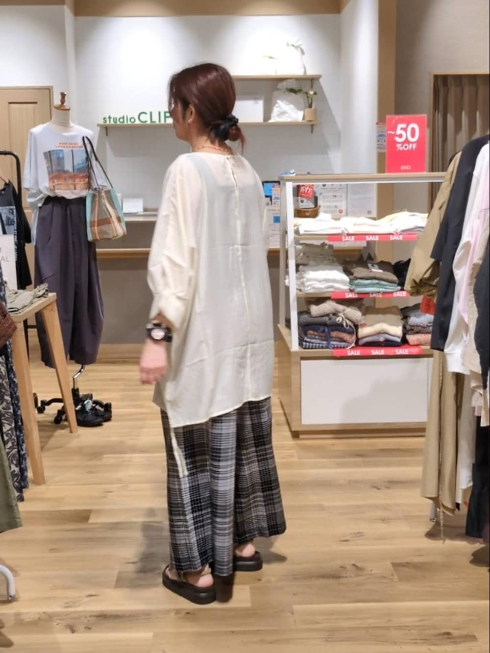ベージュ系のサンダル、ホワイト系のその他パンツ、ブラック系のショルダーバッグを着用したレディースの夏コーディネートの2枚目の写真