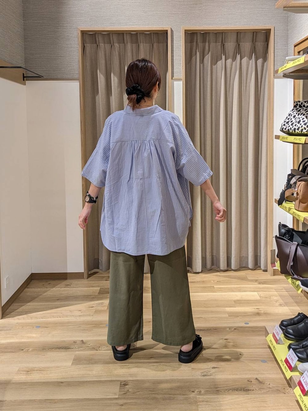 ブラック系のサンダル、グリーン系のその他パンツ、ブラック系のトートバッグを着用したレディースの春コーディネートの2枚目の写真