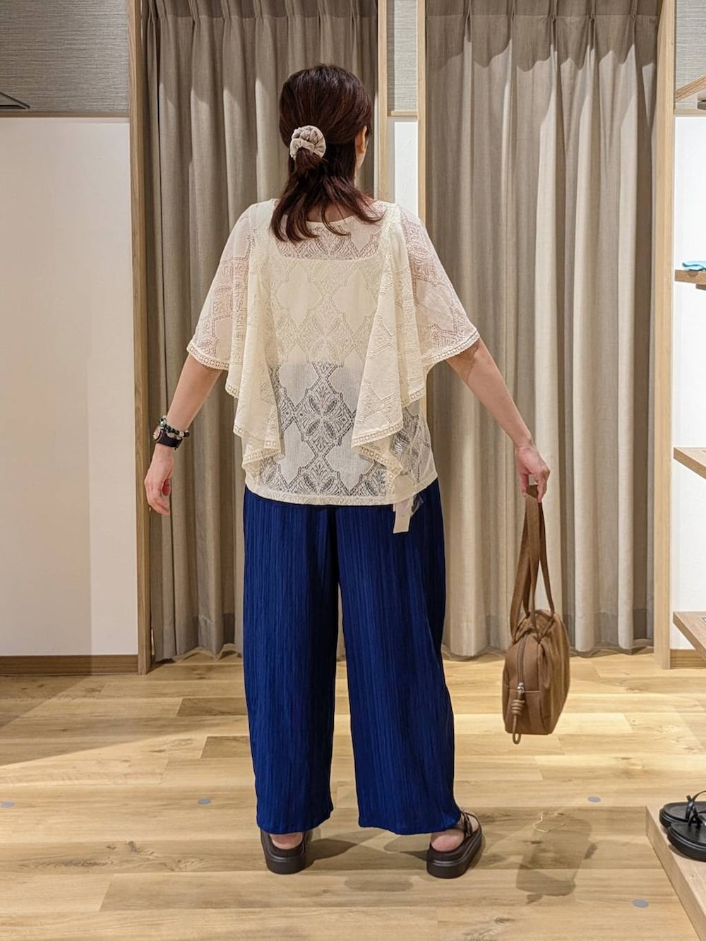 ブラウン系のショルダーバッグ、ベージュ系のシャツ/ブラウス、ブルー系のその他パンツを着用したレディースの夏コーディネートの2枚目の写真