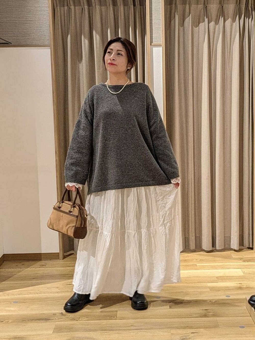 ブラック系のブーツ、グレー系のその他トップス、ブラウン系のショルダーバッグを着用したレディースの冬コーディネートの2枚目の写真