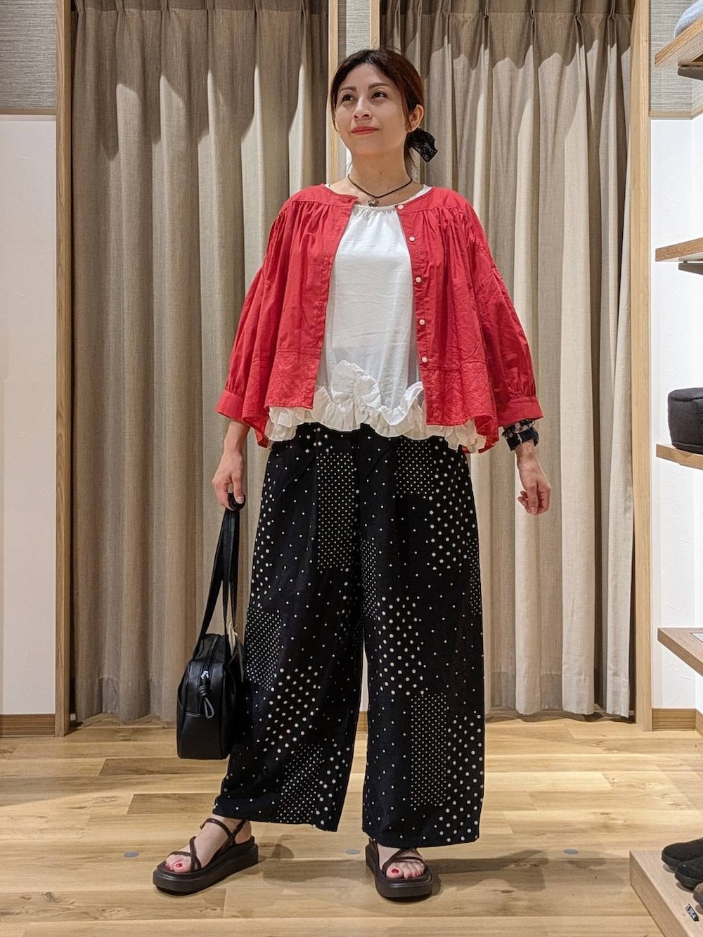 ブラック系のショルダーバッグ、レッド系のシャツ/ブラウス、ブラウン系のサンダルを着用したレディースの夏コーディネートの2枚目の写真