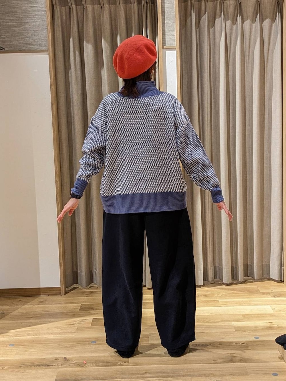 ブルー系のニット/セーター、ブラック系のパンプス、ブラウン系のショルダーバッグを着用したレディースの冬コーディネートの3枚目の写真