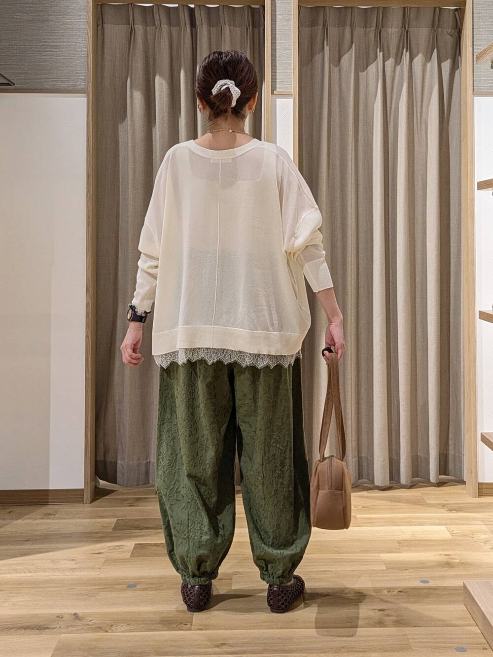 ブラウン系のショルダーバッグ、グリーン系のその他パンツ、ホワイト系のカーディガン/ボレロを着用したレディースの秋コーディネートの3枚目の写真