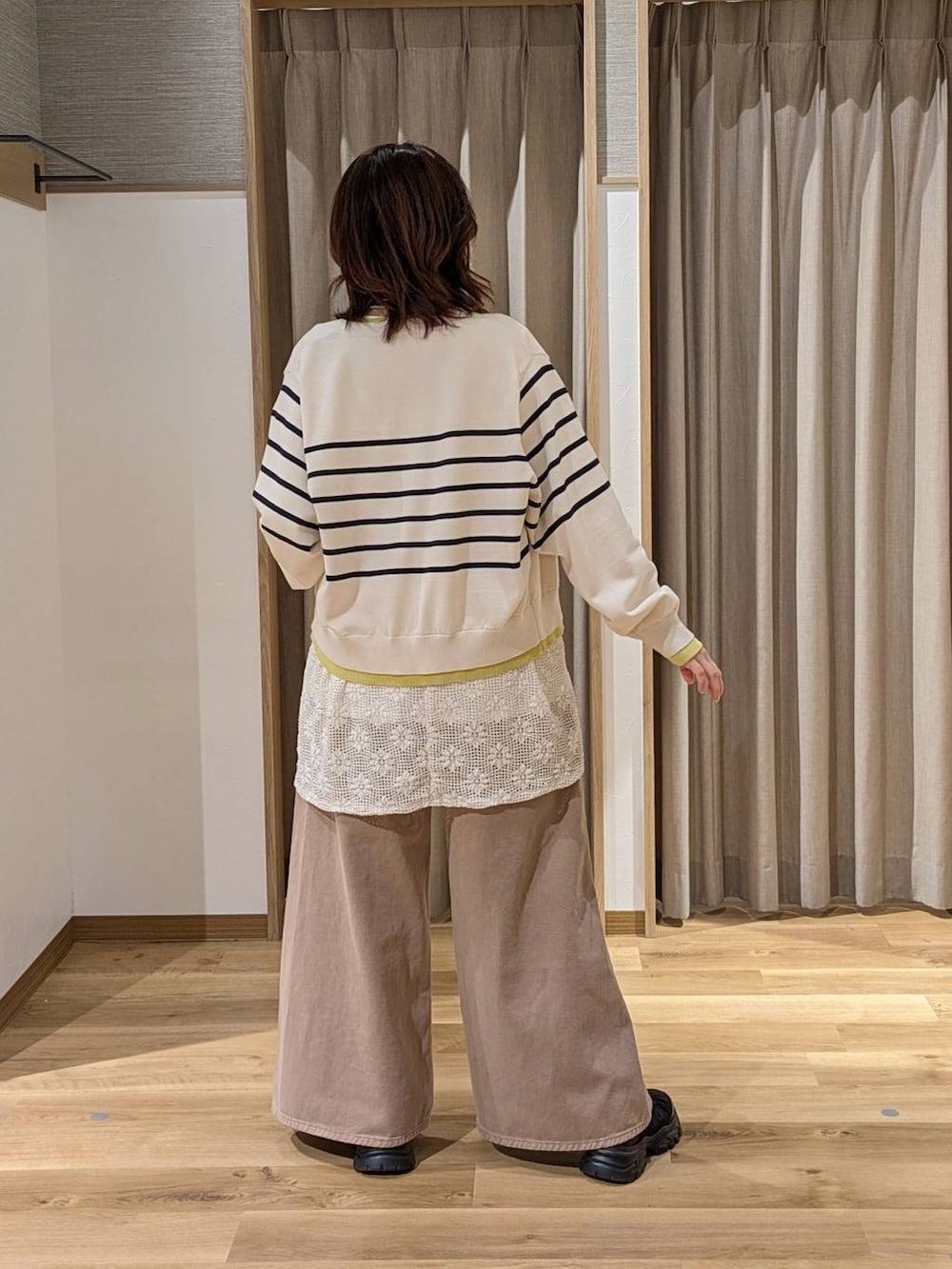 ベージュ系のデニムパンツ、ブラック系のショルダーバッグ、ブラック系のスニーカーを着用したレディースの冬コーディネートの2枚目の写真