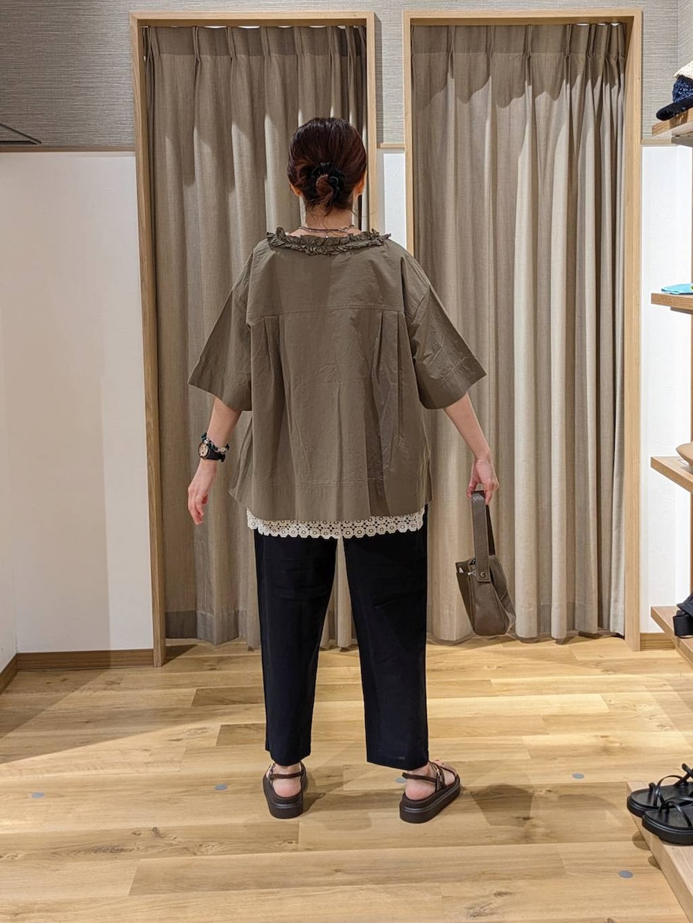 ブラウン系のサンダル、ブルー系のその他パンツ、ブラウン系のショルダーバッグを着用したレディースの夏コーディネートの2枚目の写真