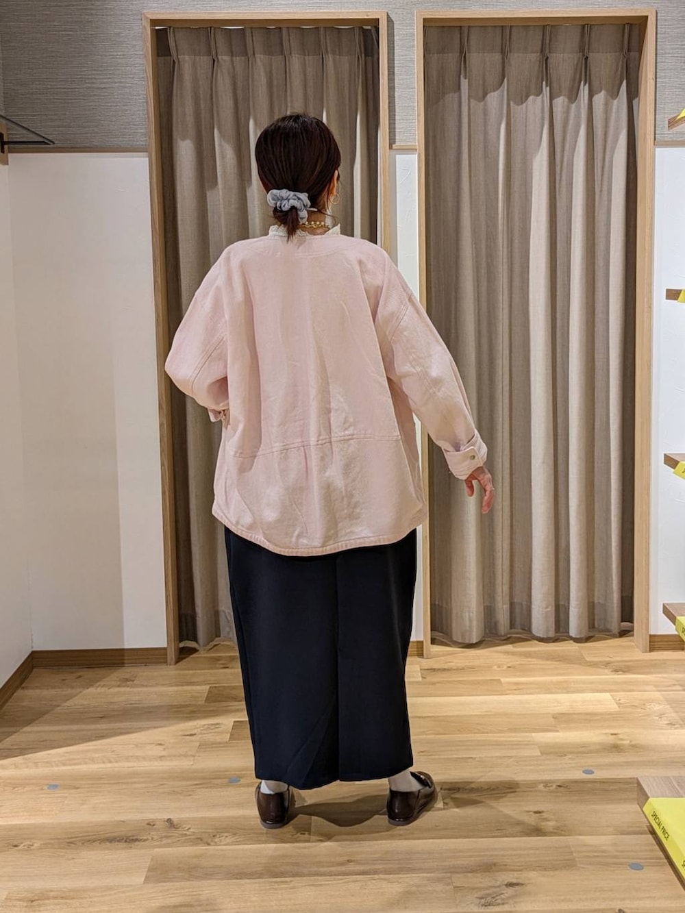 ピンク系のノーカラージャケット、ブラウン系のショルダーバッグ、ブルー系のスカートを着用したレディースの冬コーディネートの2枚目の写真