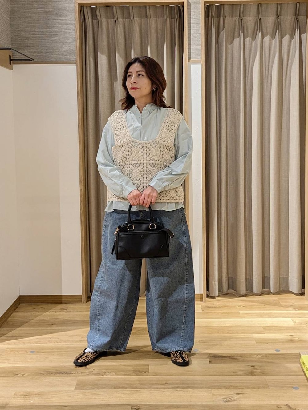 ベージュ系のベスト、ブラック系のショルダーバッグ、その他のスニーカーを着用したレディースの冬コーディネートの2枚目の写真